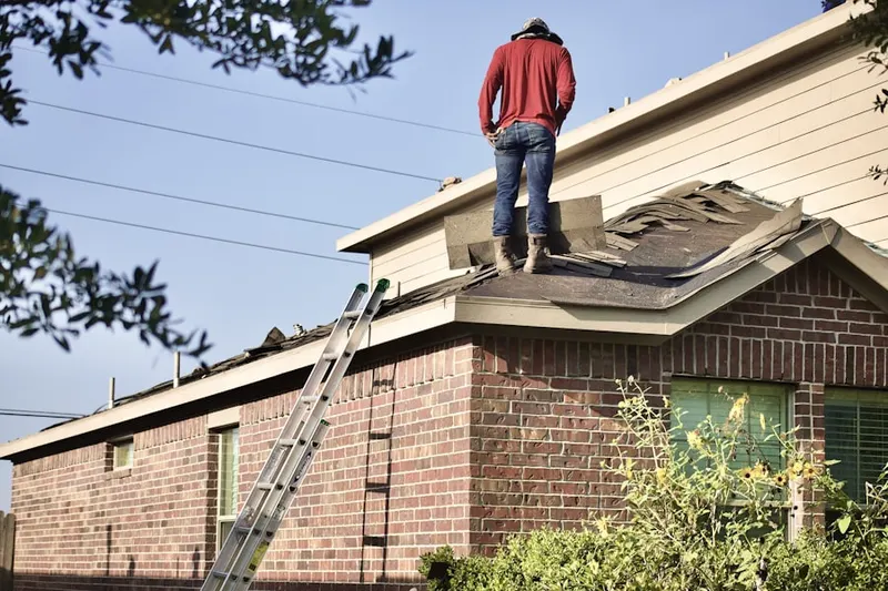 Professional roofer working on a residential roof in Dunlap Acres